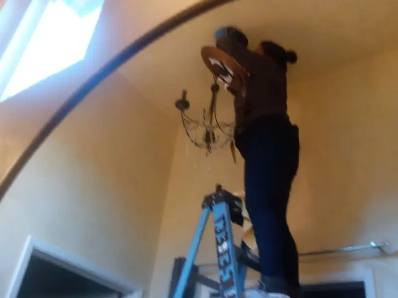 Electrician installing a chandelier in a Slatington residence